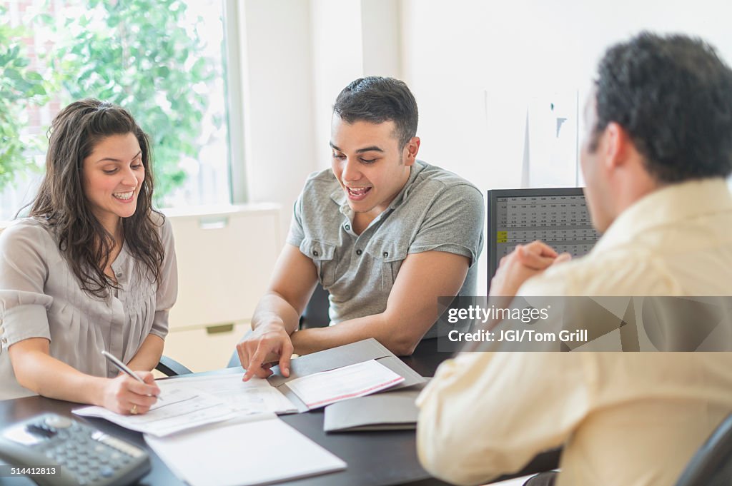 Hispanic businessman talking to clients in office