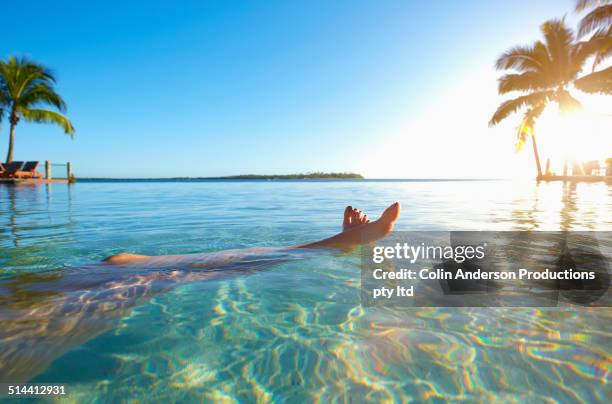 legs of caucasian girl relaxing in tropical ocean - nadi foto e immagini stock