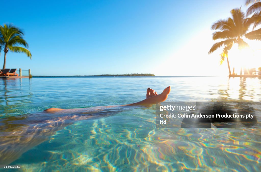 Legs of caucasian girl relaxing in tropical ocean