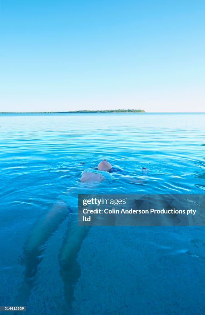 Caucasian girl swimming in tropical ocean