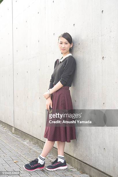 japanese woman leaning on wall,holding cell phone - harajuku fashion stock pictures, royalty-free photos & images