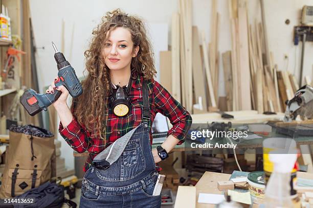 woman carpenter standing confidently in his workshop - power tool stock pictures, royalty-free photos & images