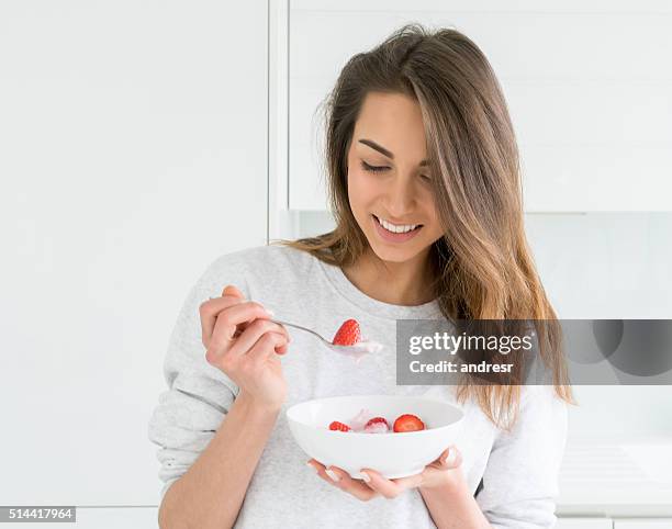 woman eating a healthy breakfast - women yogurt stock pictures, royalty-free photos & images