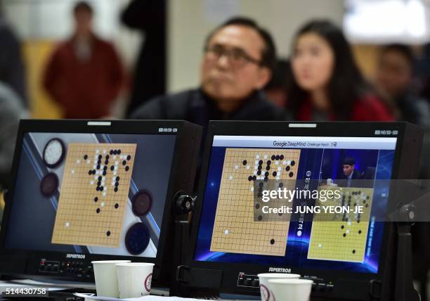 South Korean Go game fans watch a television screen broadcasting live footage of the Google DeepMind Challenge Match, at the Korea Baduk Association...