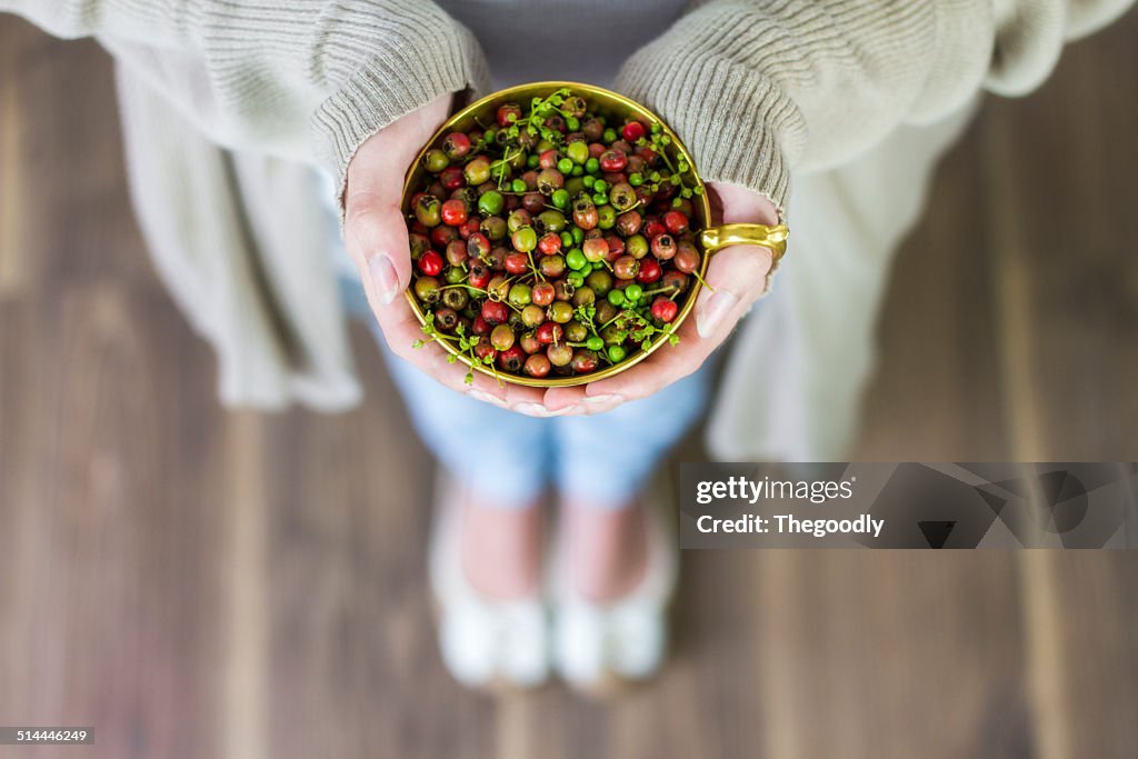 View of woman with berries in cup