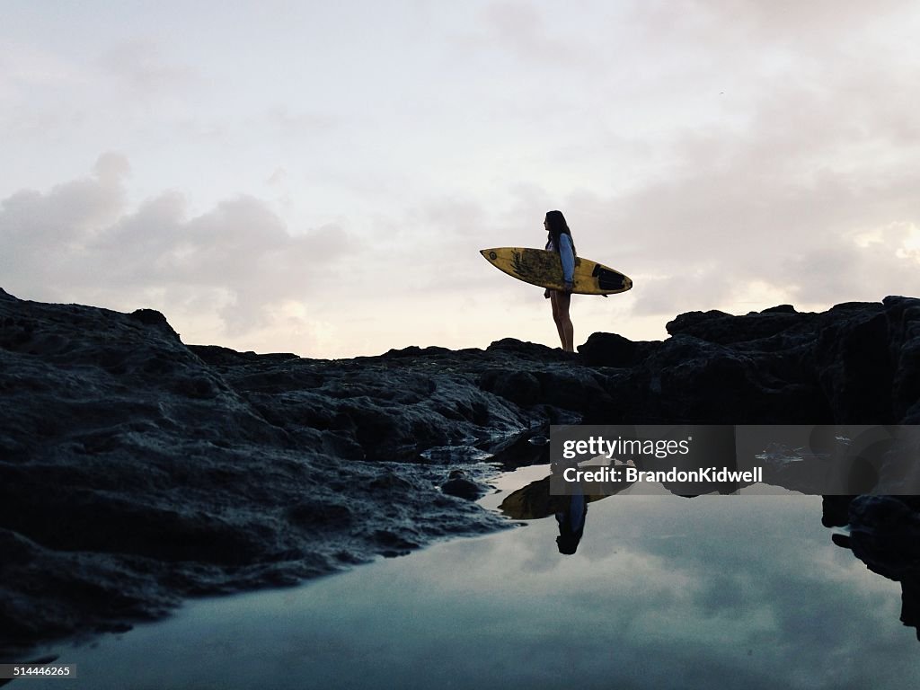 Girl standing on beach with her surfboard, Jacksonville, Florida, America, USA