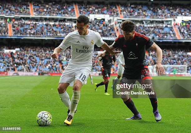 Lucas Vazquez of Real Madrid is challenged by Carles Planas of Celta Vigo during the La Liga match between Real Madrid CF and Celta Vigo at Estadio...