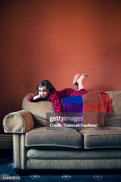 small girl lying on back of sofa - lying on back girl on the sofa stock-fotos und bilder