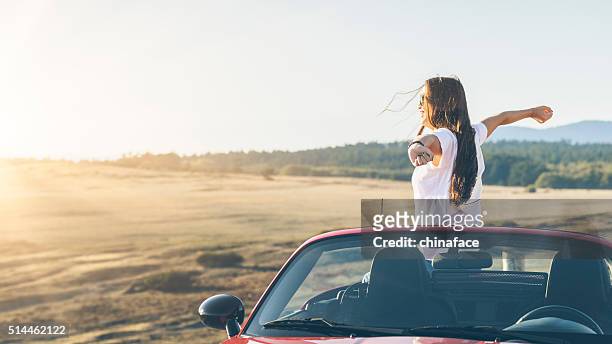 happy asian woman standing in car with arms raised - washington state road stock pictures, royalty-free photos & images