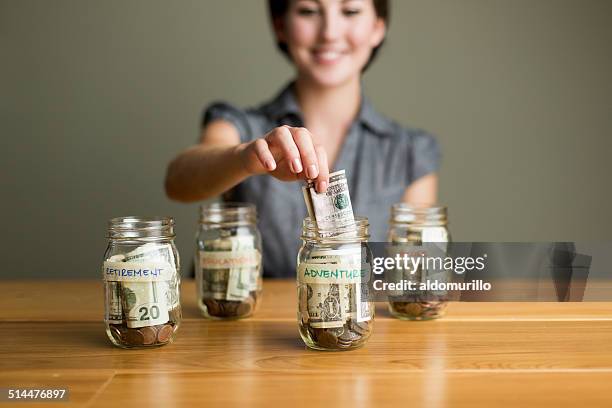 woman saving in jars - filling jar stock pictures, royalty-free photos & images