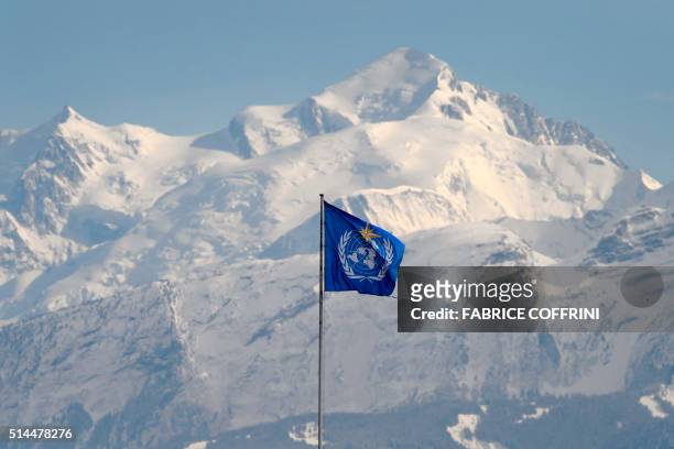 Flag of the World Meteorological Organization flies on the top of the United Nations specialized agency's headquarters in front of the Mont Blanc...