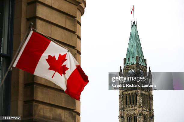 Ottawa, Canada - June 15 - The Canadian Flag flies on a building in Ottawa across from the Peace Tower on Centre Block of Parliament Hill. Stock...