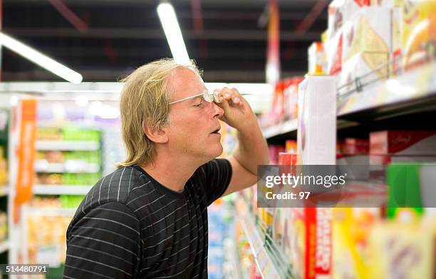 mann entscheidet sich für produkte im supermarkt - preisschild stock-fotos und bilder