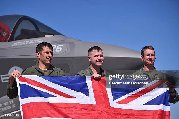 Lieutenant Commander Adam Hogg, Royal Navy, Major Ethan Howell, US Marine Corps, and Squadron Leader Hugh Nichols, RAF, pose with a Union Flag in...