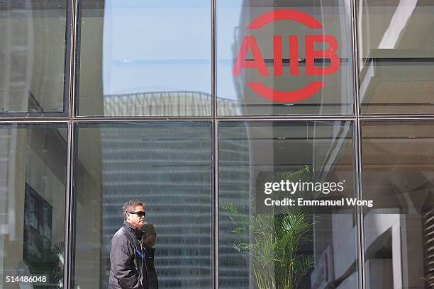 People walks pass the sign of The Asian Infrastructure Investment Bank on March 9, 2016 in Beijing, China.The Asian Infrastructure Investment Bank...
