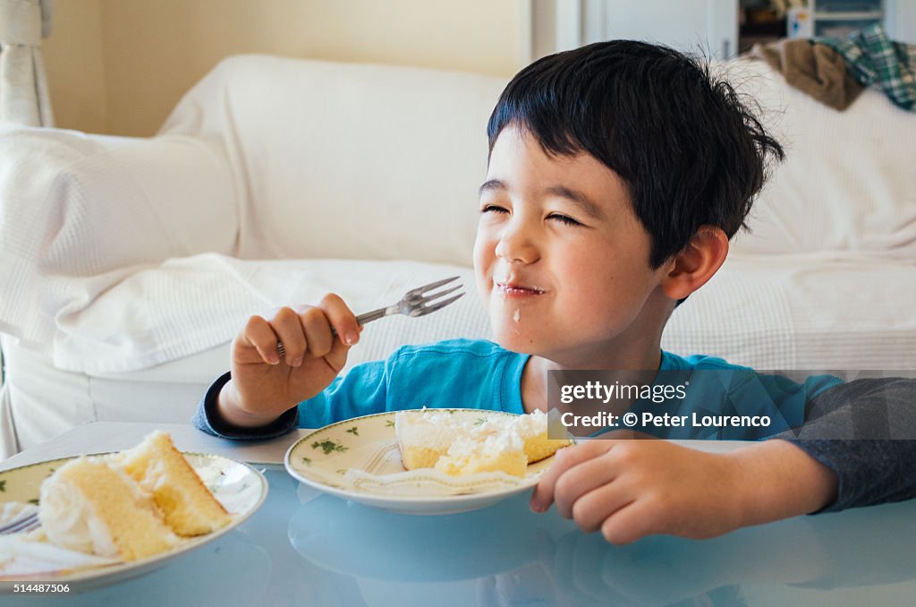 Young boy eating a slice of cake