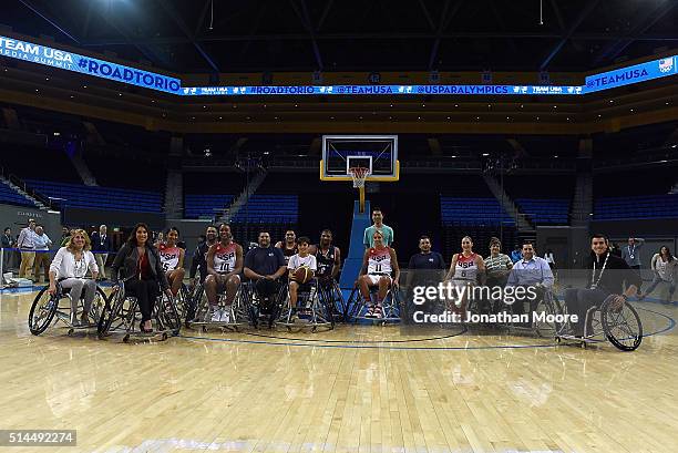 Candice Parker, Tamika Catchings, Trevon Jenifer, Elena Della Donna and Sue Bird pose with other participants after a wheelchair basketball...