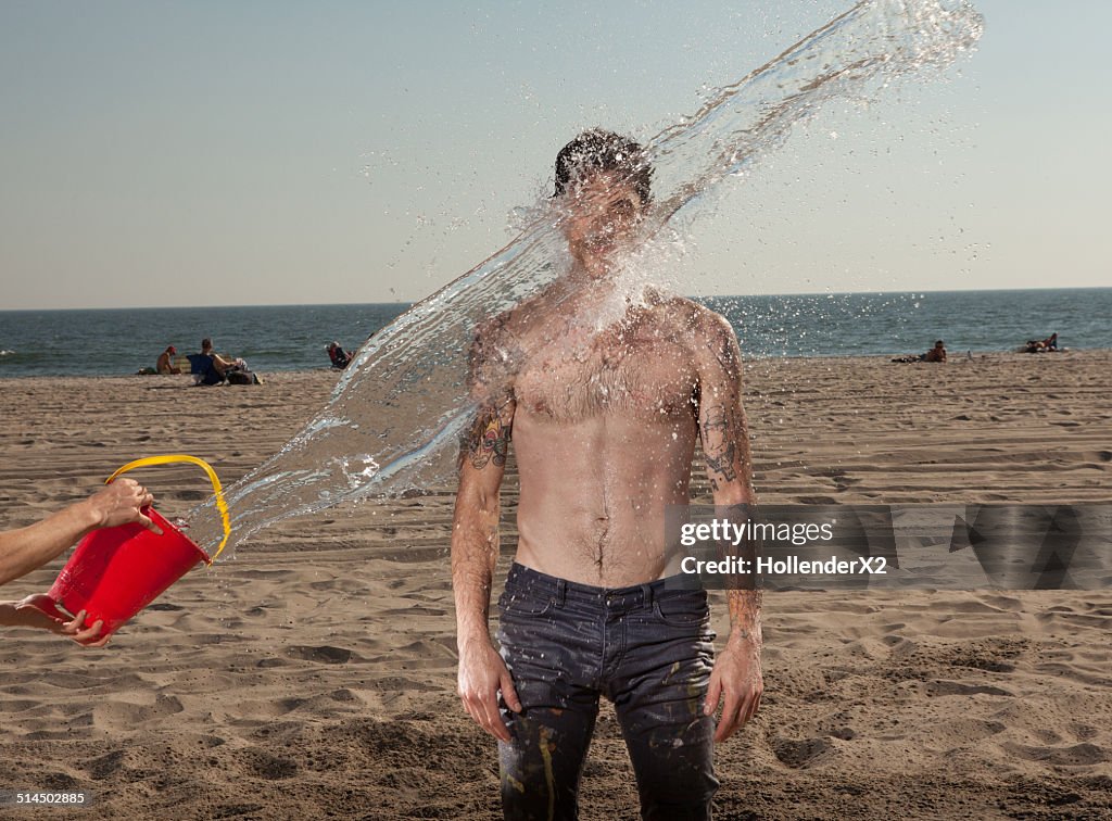 Man Getting Splashed With Bucket Of Water At Beach High-Res Stock Photo ...