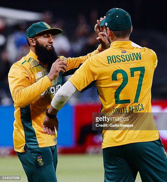 Hashim Amla of South Africa celebrates taking a catch in the deep with teammate Rilee Rossouw during the 3rd KFC T20 International match between...