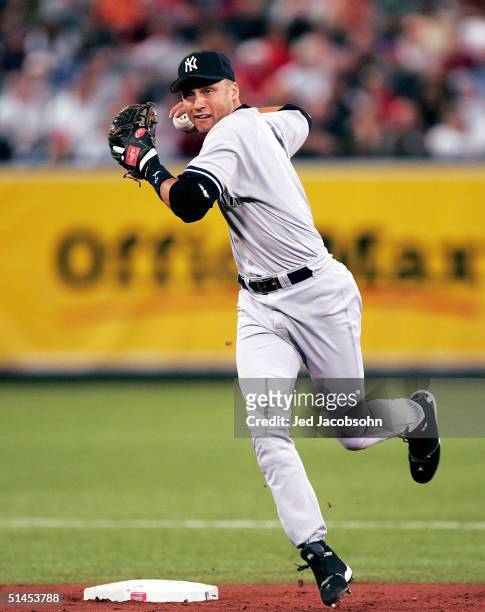 Shortstop Derek Jeter of the New York Yankees prepares to throw to first on a ball hit up the middle by Lew Ford of the Minnesota Twins during game...