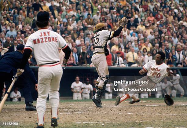 Frank Robinson of the Baltimore Orioles slides home as Pittsburgh Pirates' Manny Sanguillen reaches for the throw during the World Series at Memorial...