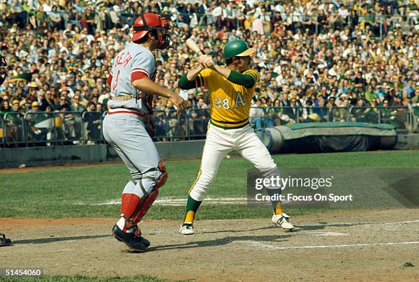 Catcher Johnny Bench of the Cincinnati Reds stands behind Gene Tenace of the Oakland Athletics getting his swing ready during the World Series at the...