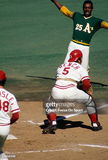 Johnny Bench of the Cincinnati Reds guards home base against the Oakland Athletics' George Hendricks as he tries to slide into home the World Series...