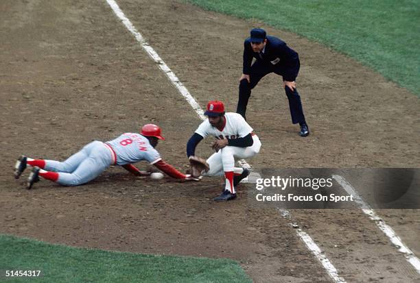 Cecil Cooper of the Boston Red Sox reaches for the throw as Joe Morgan of the Cincinnati Reds dives to get back to first base during the World Series...