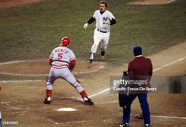 Thurman Munson of the New York Yankees tries to score while Johnny Bench of the Cincinnati Reds blocks home plate during a World Series game at...