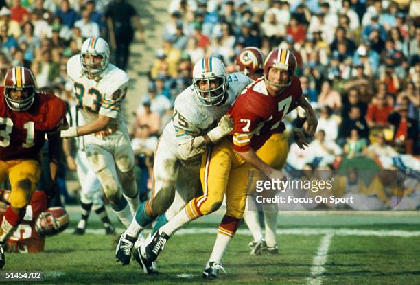 Billy Kilmer quarterback for the Washington Redskins gets tackled by Manny Fernandez of the Miami Dolphins during Super Bowl VII at Memorial Coliseum...
