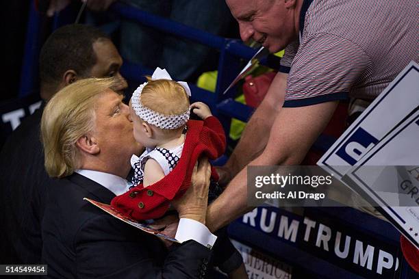 Republican presidential candidate Donald Trump kisses Dahlia May, 1-year-old, from Burgaw, N.C., after a campaign rally at the Crown Center Coliseum...