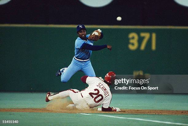 Frank White of the Kansas City Royals throws to first after forcing out Mike Schmidt of the Philadelphia Phillies during the World Series at Veterans...