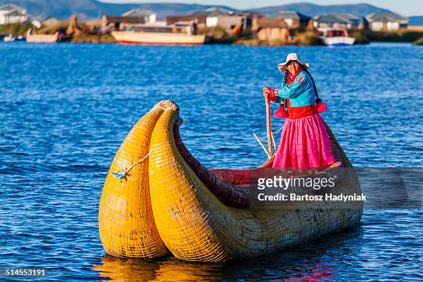 peruvian woman sailing between uros islands - uros stock pictures, royalty-free photos & images