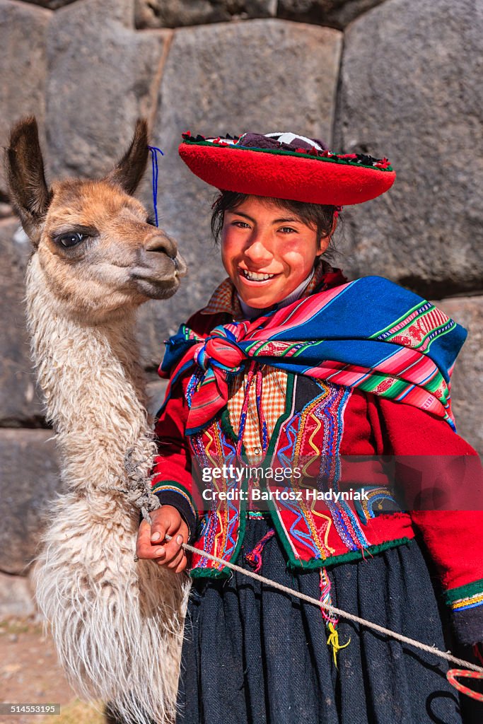 Peruvian ypung girl posing with llama near Cuzco