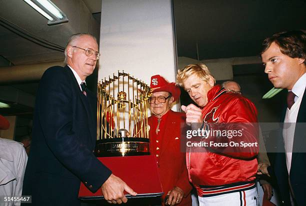 Baseball commissioner Bowie Kuhn presents St. Louis Cardinals owner August Busch and manager Whitey Herzog with the World Series trophy after Game...