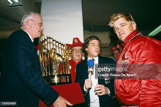 Baseball commissioner Bowie Kuhn presents St. Louis Cardinals owner August Busch and manager Whitey Herzog with the World Series trophy after winning...