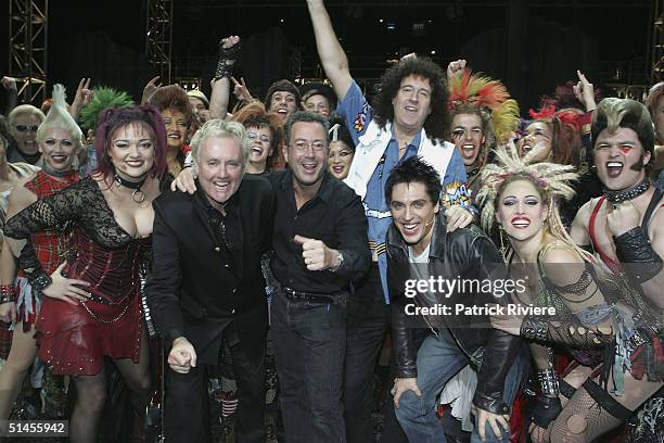 Queen's founding members Roger Taylor and Brian May pose on stage with producer Ben Elton and the cast members of "We Will Rock You" after a photo...