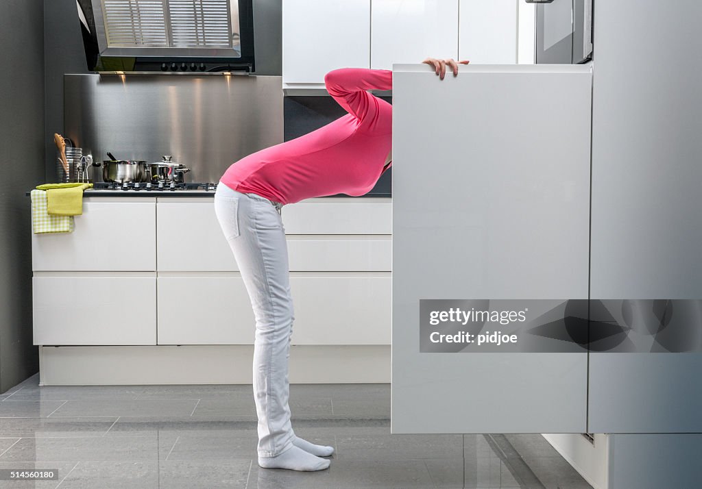 Teenage girl looking into refrigerator for a snack