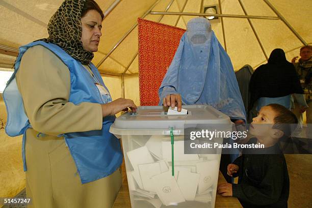 An Afghan women casts her vote in Afghanistan's first democratic election at a polling station set up in a tent at the Lamae-Shaheed Girls High...