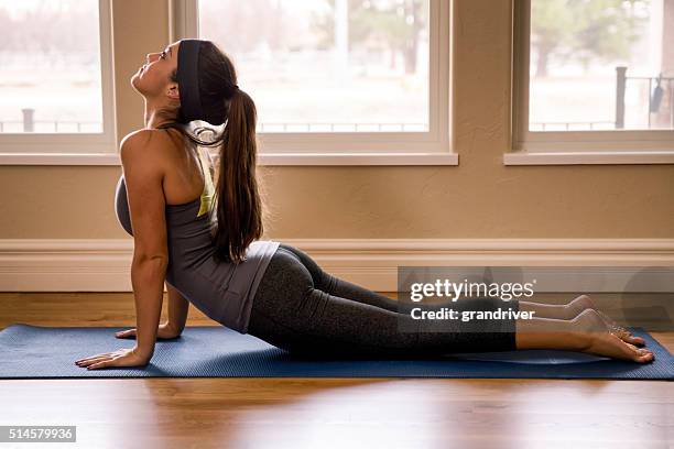 young woman doing yoga cobra pose - cobra stock pictures, royalty-free photos & images