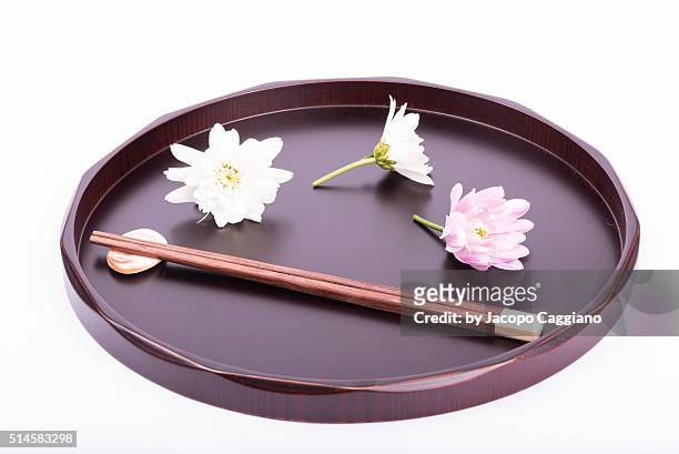 japanese composition with chopsticks and flowers on a serving plate - jacopo caggiano foto e immagini stock