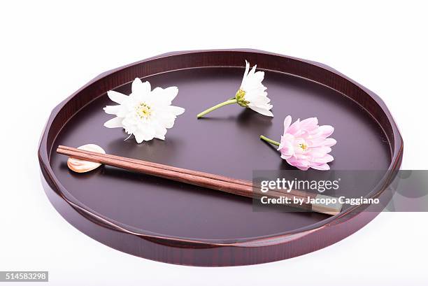 japanese composition with chopsticks and flowers on a serving plate - jacopo caggiano stockfoto's en -beelden