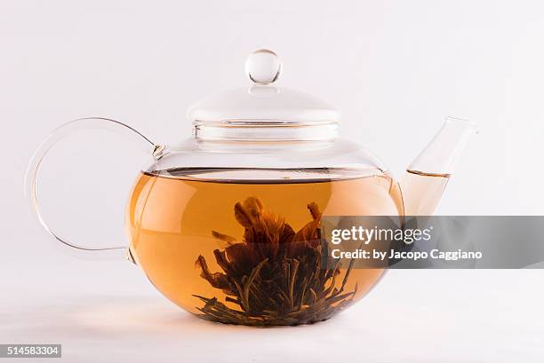 glass teapot with infused tea flower - jacopo caggiano stockfoto's en -beelden