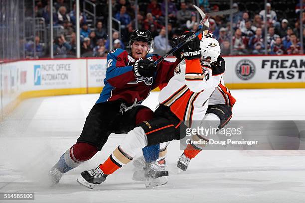 Gabriel Landeskog of the Colorado Avalanche puts a hit on Jamie McGinn of the Anaheim Ducks at Pepsi Center on March 9, 2016 in Denver, Colorado.