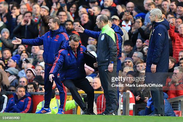 Man Utd manager Louis van Gaal falls to the ground as he imitates a dive in front of fourth official Mike Dean during the Barclays Premier League...