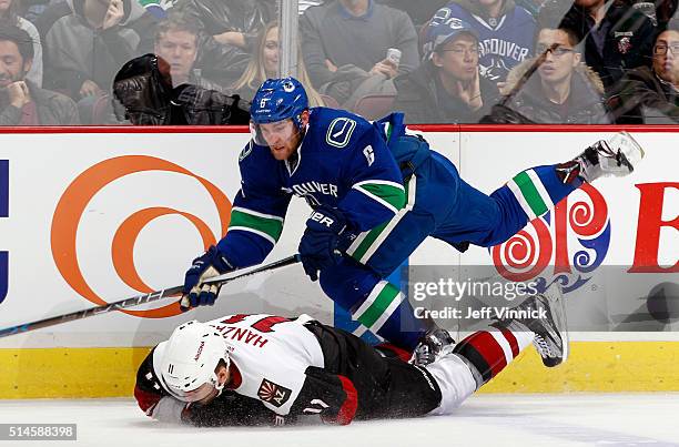 Yannick Weber of the Vancouver Canucks trips over Steve Downie of the Arizona Coyotes during their NHL game at Rogers Arena March 9, 2016 in...