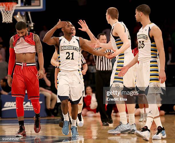 Ron Mvouika of the St. John's Red Storm reacts to the loss as Traci Carter,Henry Ellenson and Jajuan Johnson of the Marquette Golden Eagles celebrate...