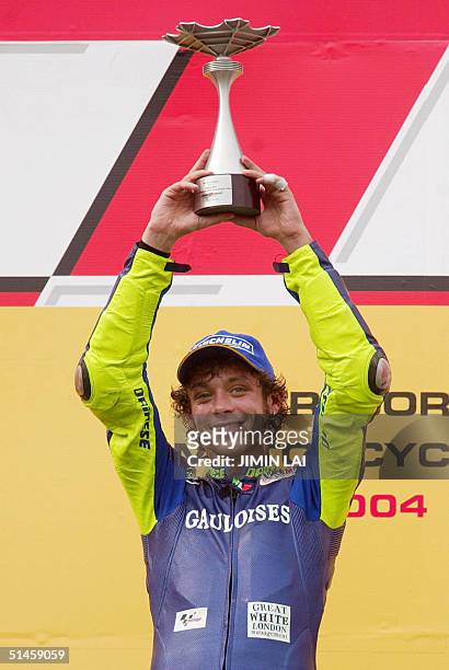 MotoGP champion Valentino Rossi of Italy raises his trophy after winning the Malaysian MotoGP in Sepang, 10 October 2004. Rossi won the Malaysian...