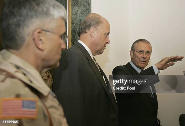 Secretary of Defense Donald Rumsfeld, right, stands with U.S. Ambassador to Iraq John Negroponte, center, and Gen. George Casey, the top American...