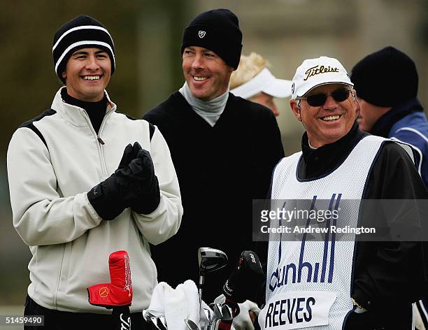 Adam Scott of Australia shares a joke with Richard Green of Australia and Butch Harmon of the United States as they wait to tee off on the second...